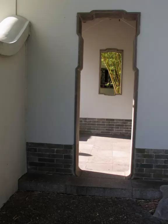 Pleasant garden with waterfall, huge lizards, boulders, pavilions with lovely circle windows and distinctive roofs, and pond, but some city noise.