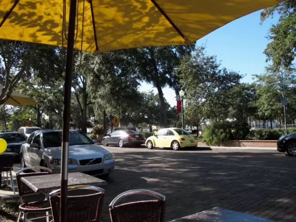 Gorgeous main street with large, European-style park where people sit on the grass by the fountain.