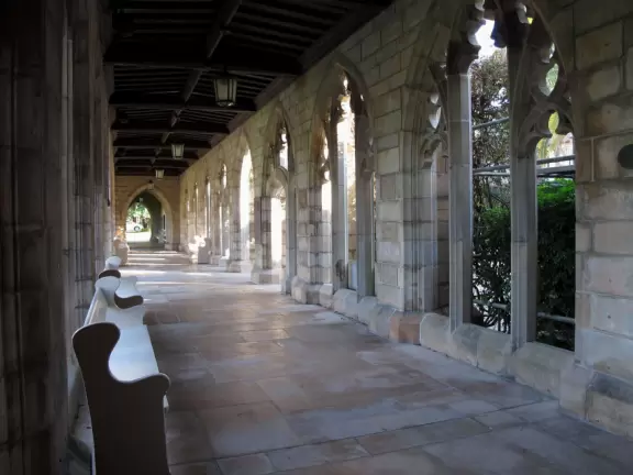 Delightful garden behind a gothic church, with lily pond, koi fish, tropical flowers, sculpted coral walls, fountain, and fresco.