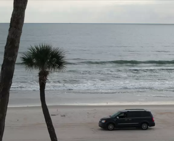Pale sand,&nbsp;shallow entry to the water, but cars driving by on the sand and awful architecture.