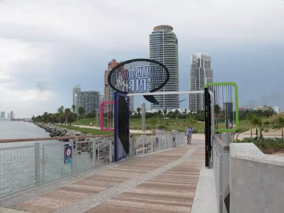 Modern pier, grass hill with winding paths, space-age playground and splash pad, and shady promenade along the water.
