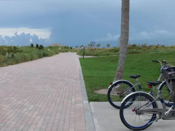 Modern pier, grass hill with winding paths, space-age playground and splash pad, and shady promenade along the water.