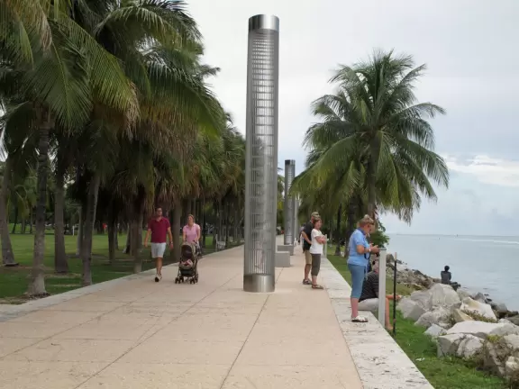 Modern pier, grass hill with winding paths, space-age playground and splash pad, and shady promenade along the water.