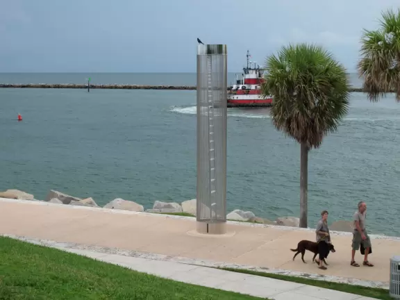 Modern pier, grass hill with winding paths, space-age playground and splash pad, and shady promenade along the water.