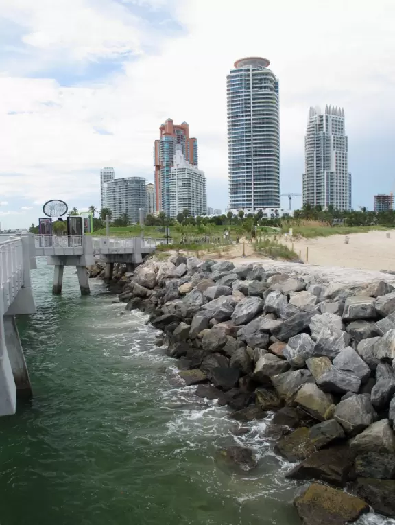 Modern pier, grass hill with winding paths, space-age playground and splash pad, and shady promenade along the water.