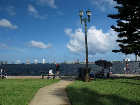 Pretty park along the intracoastal waterway near high rises, with walking paths, playground, gazebos, fountain, and tennis courts.