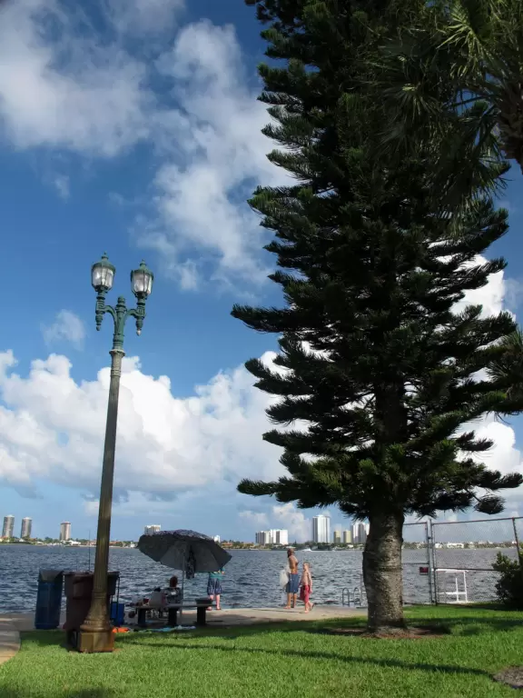 Pretty park along the intracoastal waterway near high rises, with walking paths, playground, gazebos, fountain, and tennis courts.
