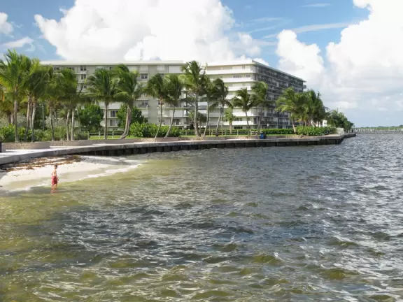Pretty park along the intracoastal waterway near high rises, with walking paths, playground, gazebos, fountain, and tennis courts.