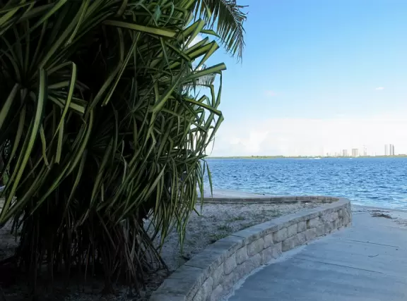 Pretty park along the intracoastal waterway near high rises, with walking paths, playground, gazebos, fountain, and tennis courts.
