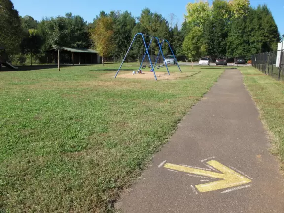Basic park with big kid and toddler playground, swings, and nice tricycle path.