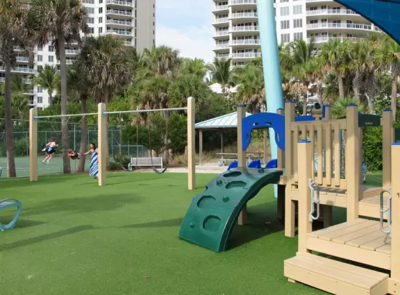 Beach with everything a beach should have: pale sand, aquamarine water, coconut palms, dunes, fit people, and cafes.