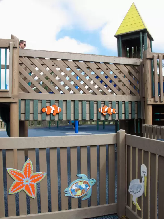Super fun ocean-themed wooden playground with ship, shark to climb, stepping stones, tire swing, see saw, mist, and mosaic mermaid castle.