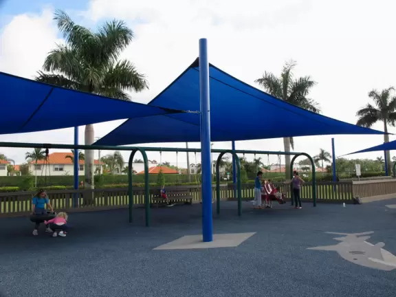 Super fun ocean-themed wooden playground with ship, shark to climb, stepping stones, tire swing, see saw, mist, and mosaic mermaid castle.