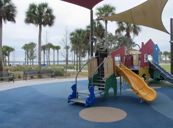 Beautiful lakefront park with wide walking paths, lighthouse, water lilies and other water flowers, birds, large playgrounds, and marina.