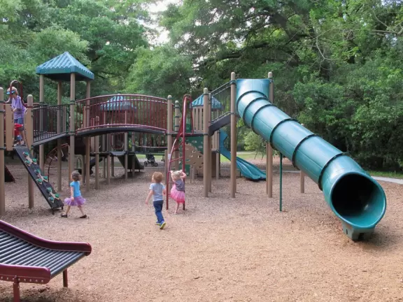 Running trails under incredible tall trees, large playground, and tennis, racquetball, volleyball and basketball courts.