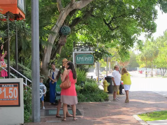 Outdoor shopping plaza and area with shaded streets and sidewalk cafes.