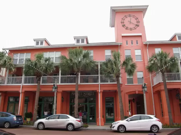 A popular town center with sidewalk cafes leading down to a pretty lake with a walking path.