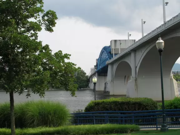 Carousel and splash pad in a park on the river with views of the blue bridge.