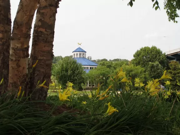 Carousel and splash pad in a park on the river with views of the blue bridge.