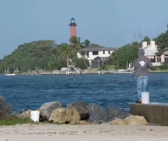 Beach where fishermen hang out on the jetty and surfers come to ride the waves at Jupiter Inlet.