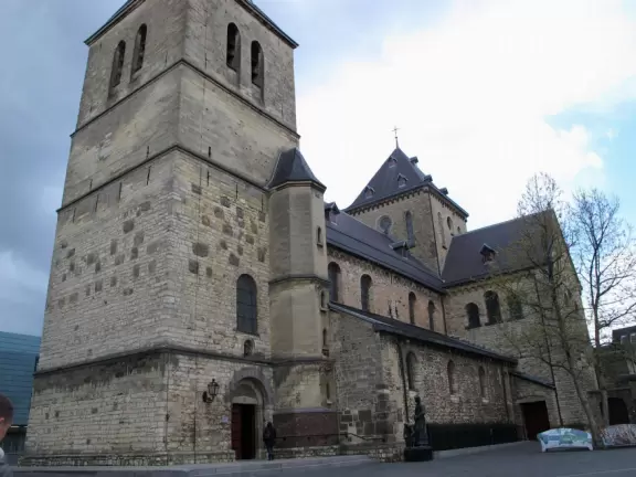 Town center with historic storefronts, large square, stone church, and outdoor cafes with flowerboxes.