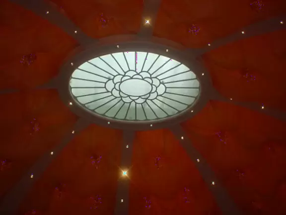 Glitzy hotel in Las Vegas, with a giant mountainside covered in trees and a waterfall, and a colorful, fairytale interior.