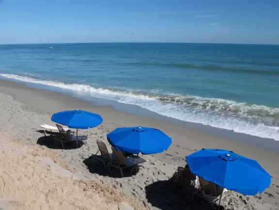 Lovely beach with thin ribbon of sand backed by high walls of dunes, and across the street, a playground with white sand and swings.