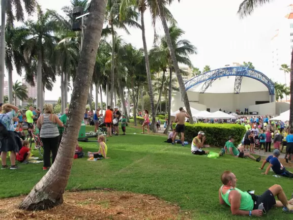 Wide walking path along the water with tropical flowers, piers, grand high rises, and palm trees- no shade though.