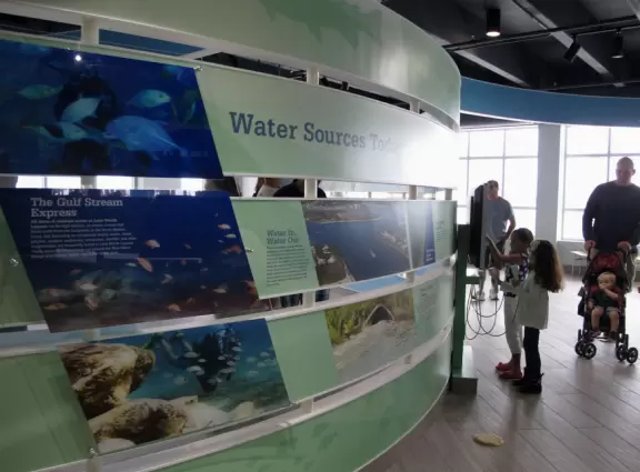 Two-level modern winter manatee viewing center with walkway by the water.