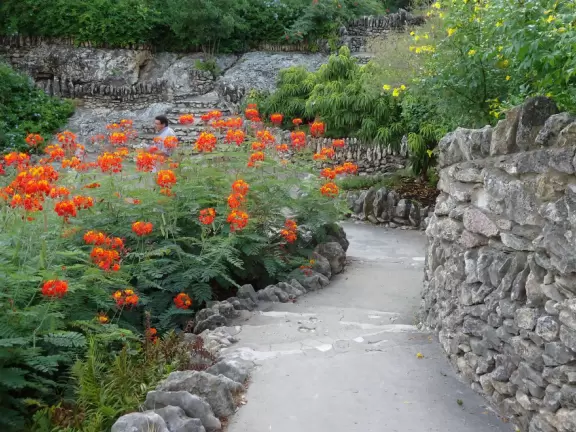 Beautiful garden in a former rock quarry, with high waterfall, stone bridges, flowers, an island, koi ponds, cafe, Japanese torii gate, and a Japanese pagoda.