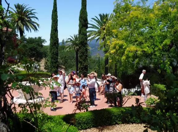 A tour group gathers, surrounded by lush foliage.