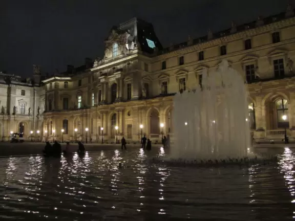 A glass and metal pyramid in the entry courtyard of the Louvre Museum, truly glorious at night!