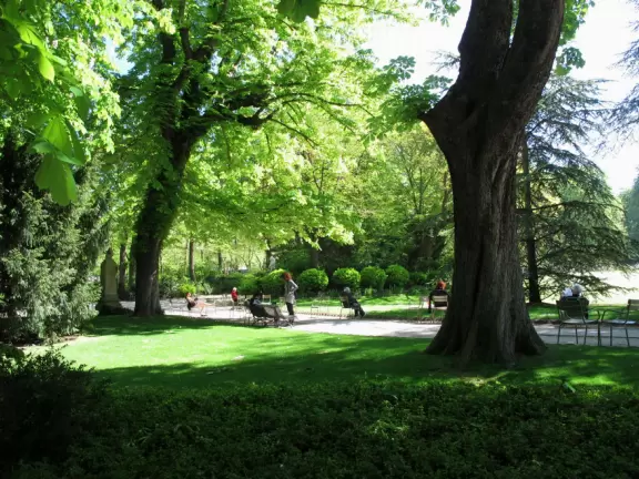 Incredible, large garden near the Sorbonne with flowerbeds, palace, circular pool with toy boats, statues, and tree canopies.