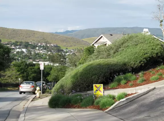 Bike path with views of hills all around, and pretty neighborhood nearby.
