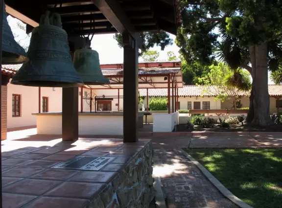 Spanish mission from late 18th century, in downtown San Luis Obispo, with giant roses in the garden behind and a lively plaza in front.