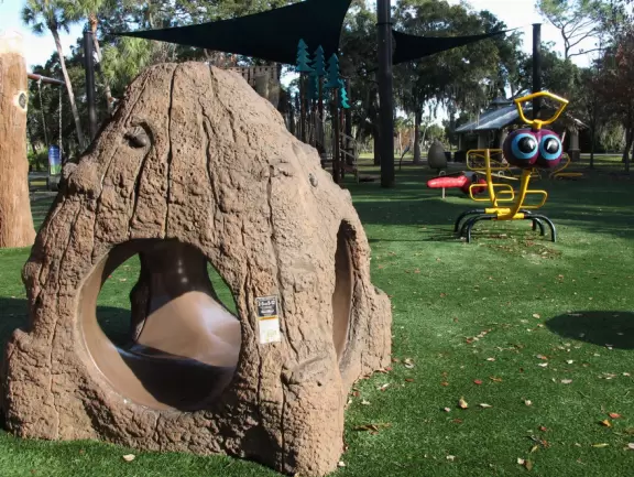Lovely forest-themed playground, along the bike path, with water and pier across the street.