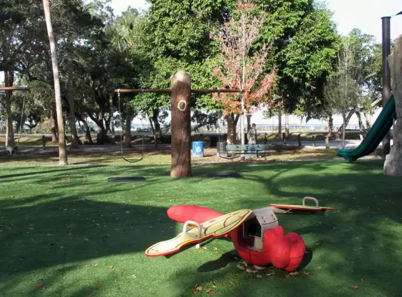 Lovely forest-themed playground, along the bike path, with water and pier across the street.