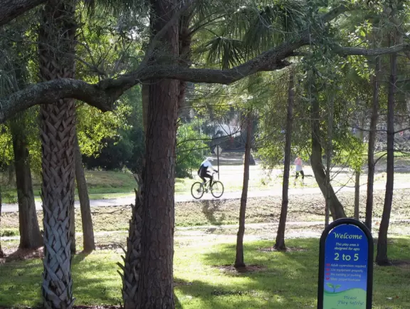Lovely forest-themed playground, along the bike path, with water and pier across the street.