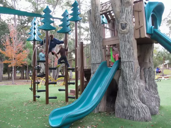 Lovely forest-themed playground, along the bike path, with water and pier across the street.