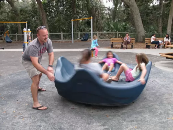 Playground in a forest setting with water/mud play.