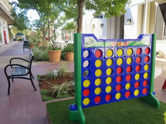 A pretty mall filled with flower pots and giant sized games, with views of the mountains and plenty of stores for kids!