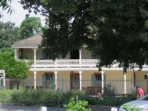 Small park with creek, adobe house, flower baskets, a few shops.