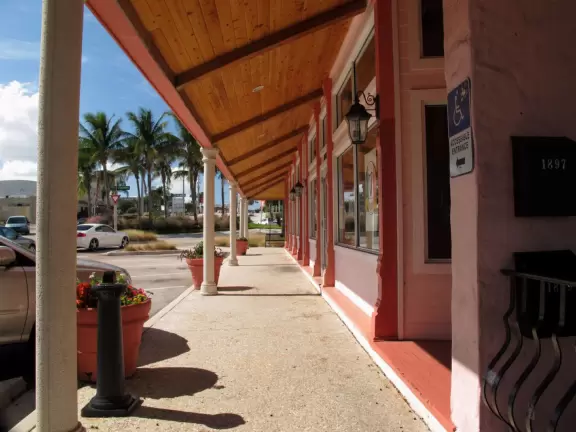 Main block with tropical-themed cafes and views of the water, plus a coffee shop and gift shops in little houses.