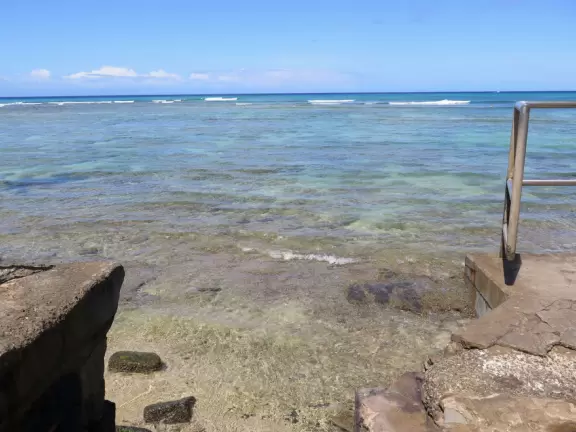 A tiny wall and walkway by the sea.