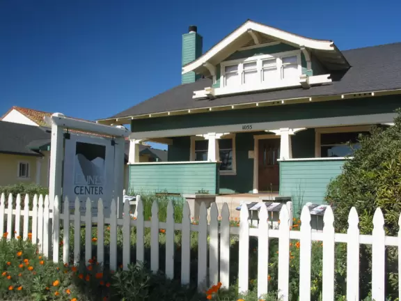Wooden boardwalk leading over a lake, past wildflowers, and to large dunes.