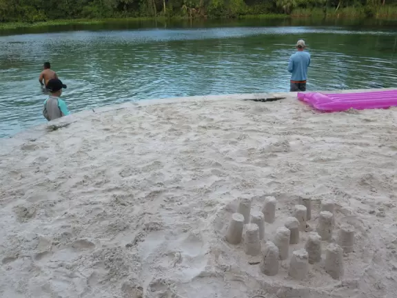 Called a spring, but more like a river, with a small white sand area where kids can play.