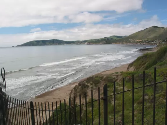 Stretch of grass with a paved walkway, flower beds, wonderful ocean views to Avila Beach, and monterey cypress trees.