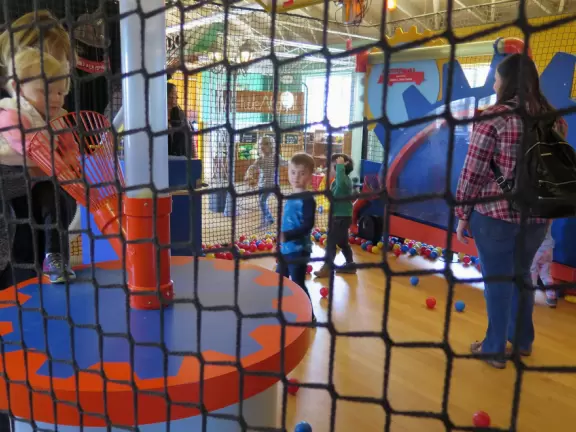 Attractive children's museum with market and carts, Newton's playhouse where you can shoot balls, ball pit, fire engine, oak tree tunnels, stage, dress-up area, and pizza kitchen.