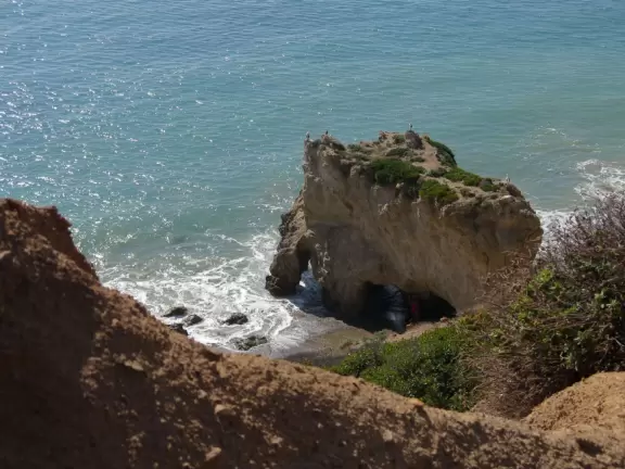 Incredible beach with blue-green water, rocks jutting out of the sea, arches, and caves.