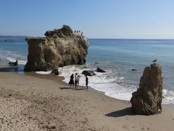 Incredible beach with blue-green water, rocks jutting out of the sea, arches, and caves.